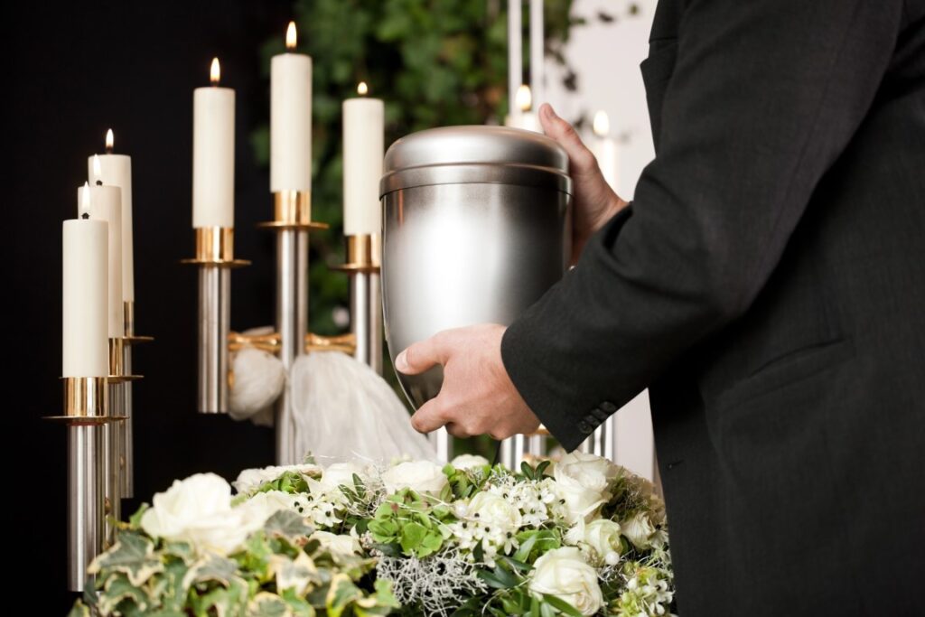 Man gently placing a cremation urn on a pedestal during a memorial service in Sydney